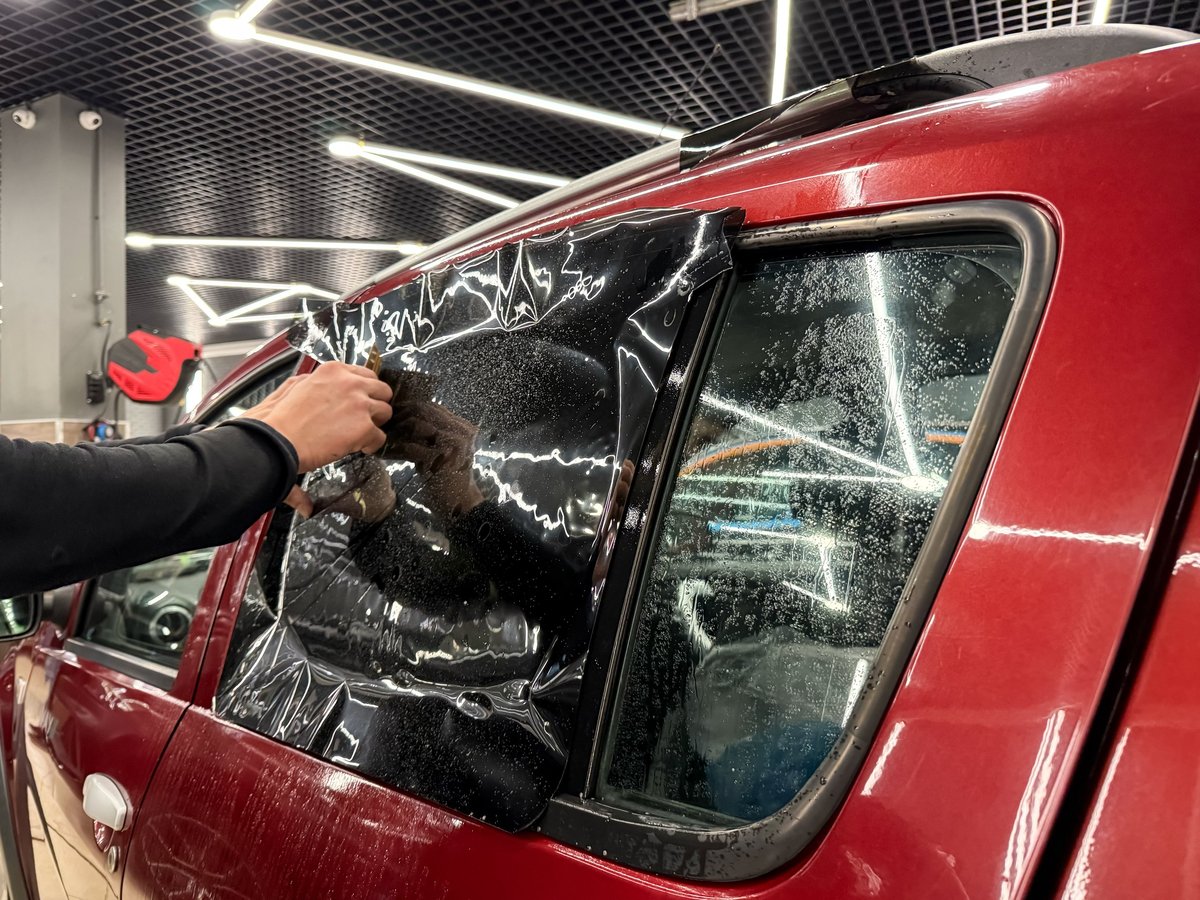 Professional window tint installation on car